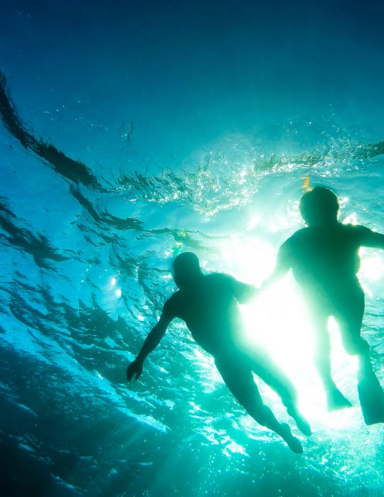 Silhouette of senior couple swimming together in tropical sea - Snorkeling tour in exotic scenarios - Concept of active elderly and fun around the world - Soft focus due to backlight and water density